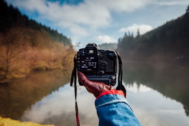 Holding camera looking at lake